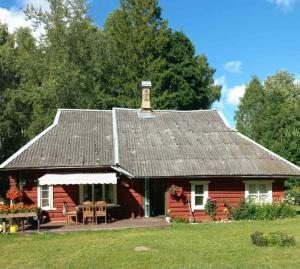 a red cabin with a porch and a roof at Muhu Garden Cabin in Suuremõisa
