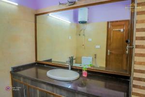 a bathroom with a sink and a large mirror at The Mint Resort in Gurgaon +8 photos