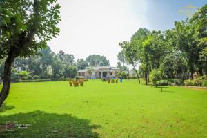 a park with picnic tables in front of a house at The Mint Resort in Gurgaon