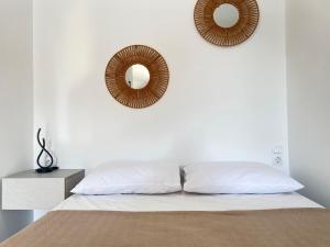 a white bedroom with two mirrors on the wall at Kohyli in Lefkada