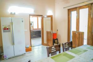 a kitchen with a refrigerator and a table and chairs at The Mint Resort in Gurgaon
