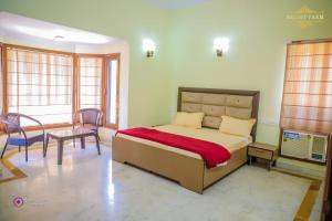 a bedroom with a bed and a table and chairs at The Mint Resort in Gurgaon