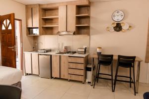a kitchen with a counter and two bar stools at Wilkoppies Self Catering in Klerksdorp