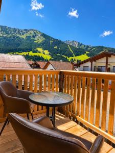 a patio with a table and chairs on a deck at s'Morent in Zöblen