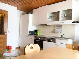 a kitchen with white cabinets and a wooden ceiling at Ferienhaus Huber in Bleiburg