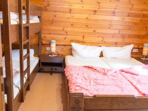 a bedroom with two beds and a wooden wall at Ferienhaus Huber in Bleiburg