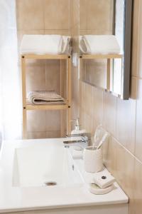 a bathroom with a sink and a mirror and shelves at House Santa Rita in Turin