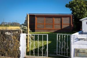 a house with a gate and a stone wall at Trendy Villas Hostel in Vila Chã