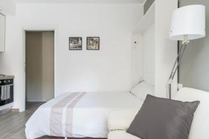 ミラノにあるCiaia Apartamentの白いベッドルーム(ベッド1台、ソファ付)