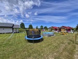 a playground with a trampoline in a field at Domki Letniskowe U Żuni in Chłopy