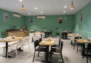 a restaurant with tables and chairs and green walls at asar Varanasi Junction by Orion Hotels in Varanasi