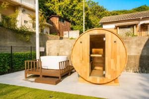 a wooden circle shaped tub sitting next to a fence at Awaji Play Resort in Minamiawaji +21 photos
