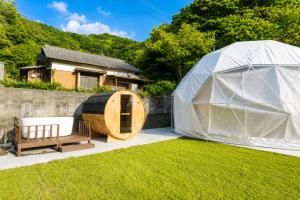 a tent and a wooden tub in a yard at Awaji Play Resort in Minamiawaji