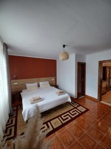 a bedroom with a large bed with white sheets at La umbra nucului bătrân in Ghimbav