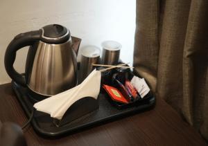 a tray with a tea kettle on a table at Hotel Laasya Grand in Vijayawāda