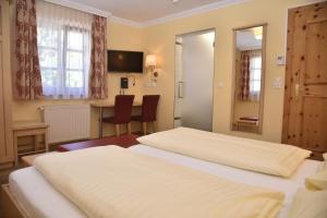 a hotel room with two beds and a desk at Hotel Gasthof Kamml in Wals