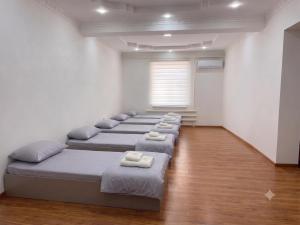 a room with a row of beds with towels on them at Хостел18А in Nukus