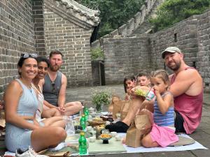 a group of people sitting around a picnic table at BeiJing Mutianyu Hills Pool Wall Resort view at the foot of Mutianyu Great Wall, infinity pool, one-way PEK airport pick-up, free laundry and coffee in Huairou