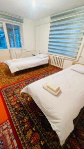 two beds in a room with two windows at Guest house Kyial in Naryn