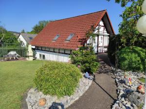 a house with a red roof and a garden at Ferienhaus 'am Aartalsee' in Ahrdt