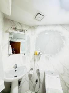 a white bathroom with a sink and a toilet at Chris Bed and Breakfast by Hostmandu in Jawlakhel +66 photos