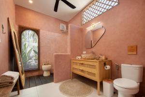 a bathroom with a toilet and a sink and a mirror at Gili Boho Villas - Aesthetic Private Pool Villas in Gili Trawangan