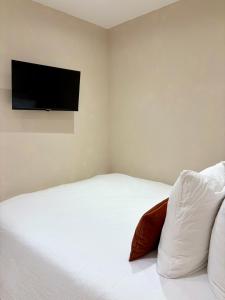 a bedroom with a bed with a television on the wall at Le Cocon Provençal in Monteux