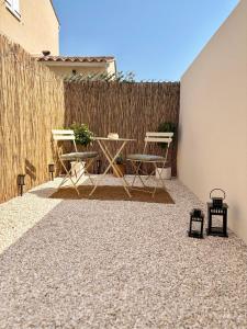 a patio with chairs and a table and a fence at Le Cocon Provençal in Monteux
