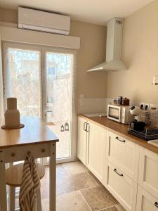 a kitchen with a table and a microwave at Le Cocon Provençal in Monteux