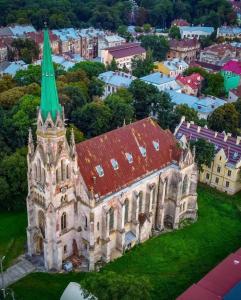 an old church with a green roof and a city at Апарт готель Метрополь in Chernivtsi