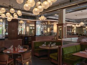 a restaurant with tables and chairs and chandeliers at Grand Mess Clermont-Ferrand in Clermont-Ferrand