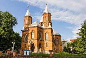 a large brick building with two towers on top at Апарт готель Метрополь in Chernivtsi