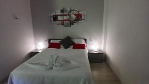 a bedroom with a bed with white sheets and red pillows at MilanoValery3 in Milan