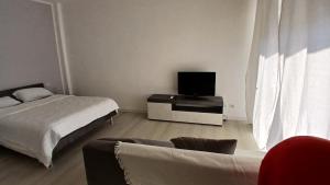 a living room with two beds and a flat screen tv at MilanoValery3 in Milan