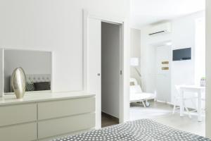 - une chambre blanche avec une commode et un miroir dans l'établissement Ciaia Apartament, à Milan