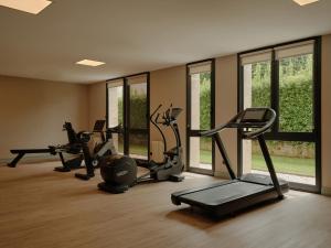 Ein Fitnessstudio mit Laufbändern und Crosstrainern in einem Raum mit Fenstern in der Unterkunft Palacio de Luces, Small Luxury Hotels in Luces