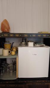 a refrigerator in a kitchen with a shelf with pots and pans at Geschmackvolles Zimmer in Steinhude in Wunstorf