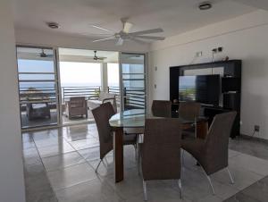a dining room with a table and chairs and a television at Casa Playa Eugen beach house with pool in El Morro