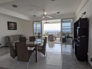 a dining room and living room with a table and chairs at Casa Playa Eugen beach house with pool in El Morro