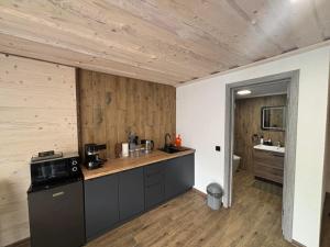 a kitchen with wooden walls and a counter top at Тиша біля річки in Izki +5 photos
