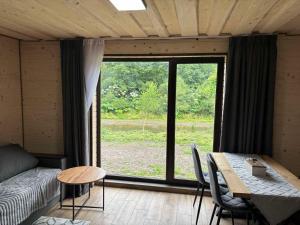 a living room with a table and a large window at Тиша біля річки in Izki