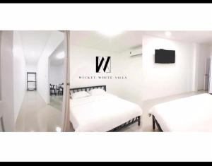 two beds in a room with a sign that reads watch white wax at WICKET WHITE VILLA in Ban Bang Lao (3)