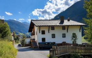 a white house with a car parked in front of it at Hotel Buckelhof - See - Free Liftpass Summer in See