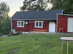 a red house with a white door and a yard at Sollidsvägen 1 F in Bro