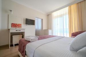 a hotel room with a bed with towels on it at Nagidos Hotel in Bozyazı +7 photos