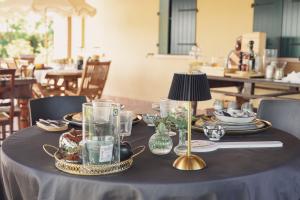 a table with plates and glasses and a lamp on it at Villa Anastasia in Carpi