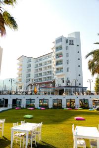 a large building with white tables and chairs in a park at Nagidos Hotel in Bozyazı