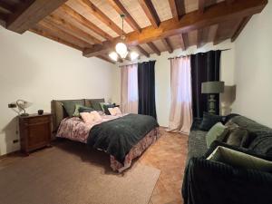 a bedroom with a bed and a couch at Villa Anastasia in Carpi