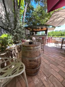 a barrel sitting on a patio with a table and chairs at Au bout du pré in Pézenas