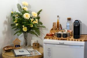 a table with a vase of flowers on top of a refrigerator at Casa do Chafariz in Cercal
